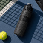 Black LABALAN Titanium Sport Water Bottle on a blue and green tennis court