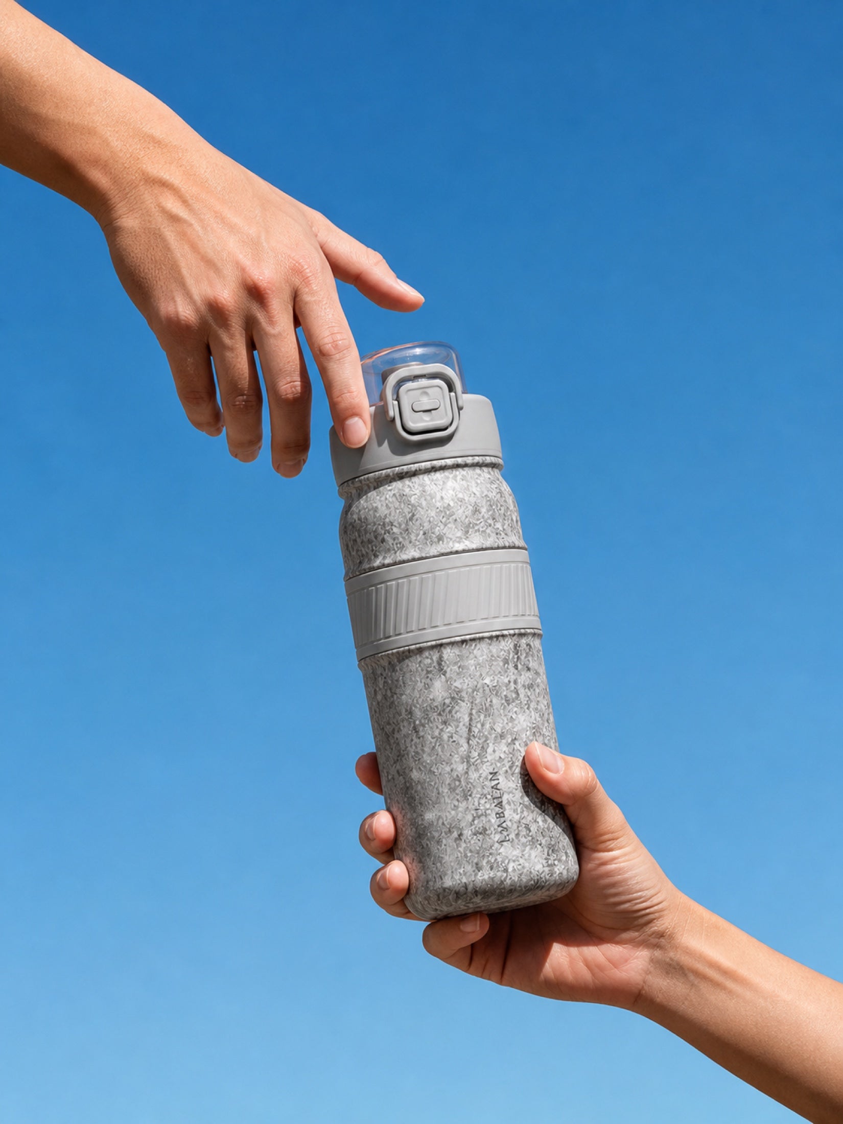 Silver LABALAN Titanium Sport Water Bottle held against a blue sky